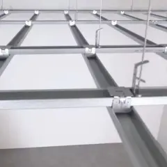 Sufit podwieszany krzyżowy z białymi panelami i metalową konstrukcją.