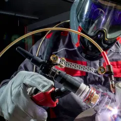 Spawacz w masce ochronnej wykonuje precyzyjne spawanie TIG. Jasny łuk spawalniczy rozświetla metal.