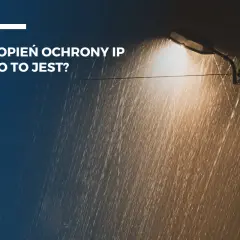 Latarnia uliczna świeci w deszczu. Tekst informuje o stopniu ochrony IP, np. IP64, który chroni przed wodą i pyłem.