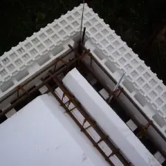 Budowa domu ze styropianu w toku. Widoczne elementy izolacyjne i zbrojenie.
