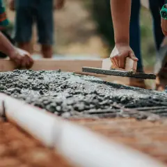 Pracownicy wyrównują świeży beton B20. Cena za m3 jest kluczowa przy planowaniu budowy.
