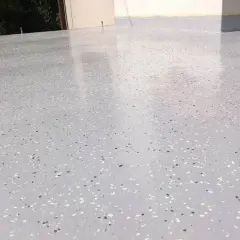 Nowoczesny kamienny dywan koszt 1m2. Jasnoszara posadzka z drobnymi, kolorowymi płatkami, idealna na taras lub balkon.