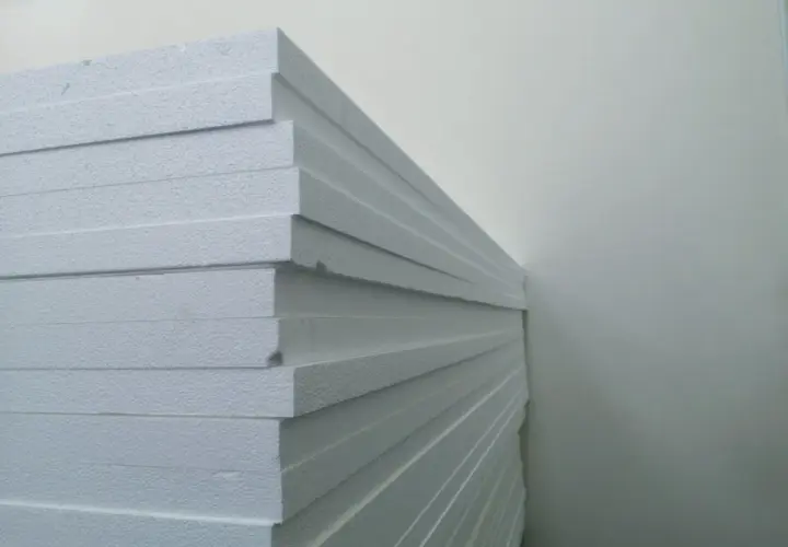 Stos białych płyt styropapa, gotowych do izolacji domu.