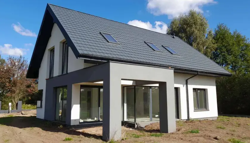 Nowoczesny dom 120 m² z szarym dachem i dużymi oknami. Zastanawiasz się, jaki koszt budowy domu 120 m²?