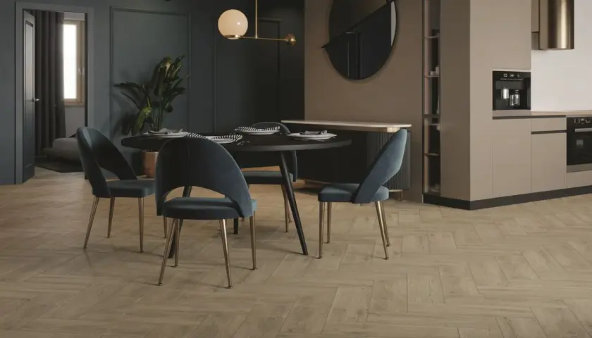 Elegancka jadalnia z granatowymi ścianami i beżową kuchnią. Drewniana podłoga w jodełkę dodaje ciepła.