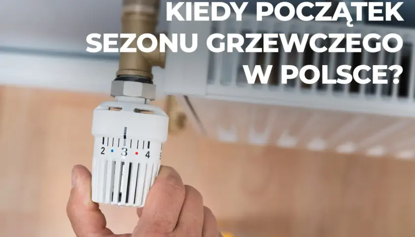 Dłoń reguluje termostat grzejnika, przygotowując dom na zimę. Kiedy zaczyna się sezon grzewczy w Polsce?