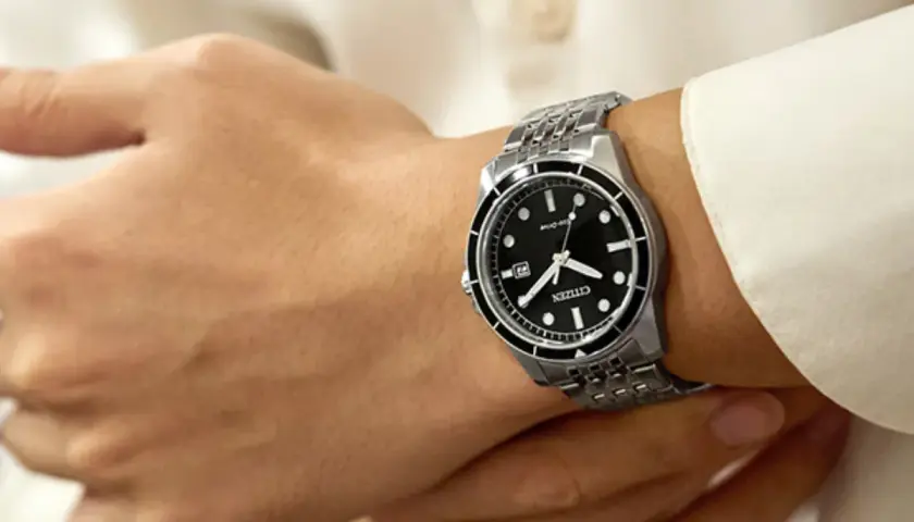 Zegarek Citizen Eco-Drive na męskim nadgarstku, na tle białej koszuli.