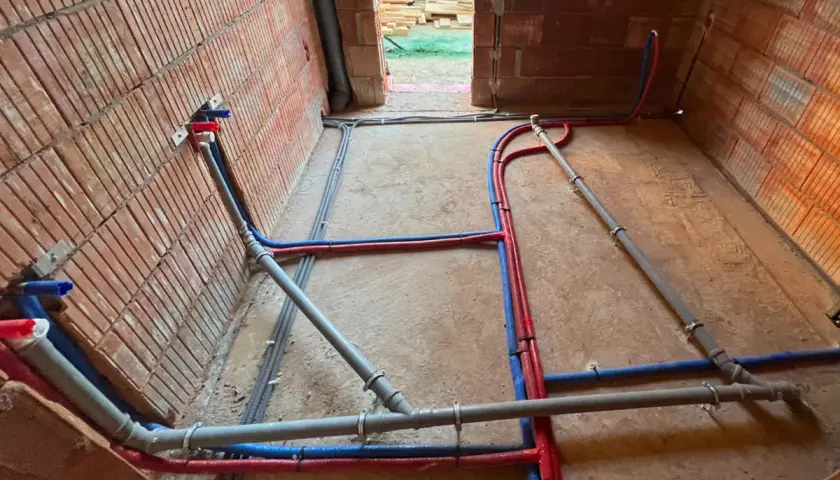 Ułożenie rur w wykopie, cennik bez materiału. Instalacja wodna i kanalizacyjna w trakcie budowy.
