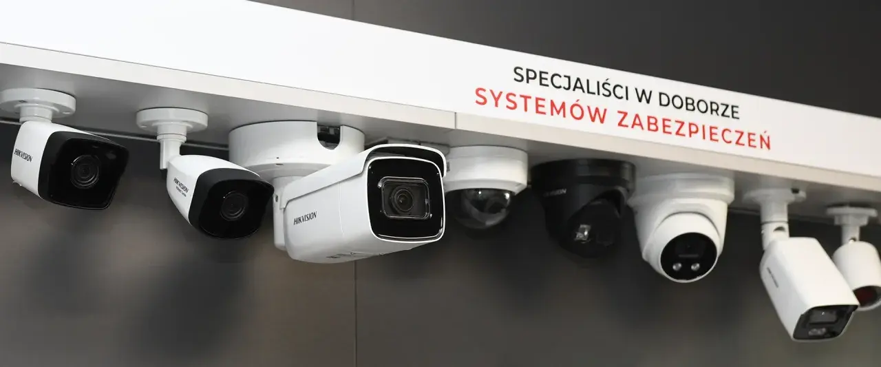 Różne kamery CCTV, od prostych po kopułkowe, prezentowane na półce. Specjaliści od systemów zabezpieczeń wiedzą, cctv co to za technologia.