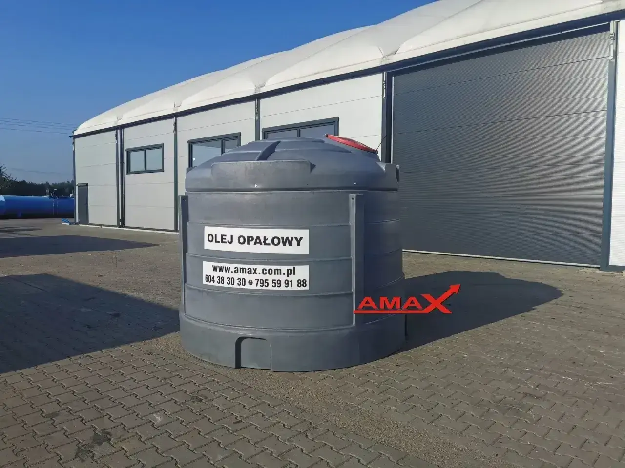 Duży zbiornik na olej opałowy przed halą magazynową. Sprawdź aktualną olej opałowy cena na amax.com.pl.