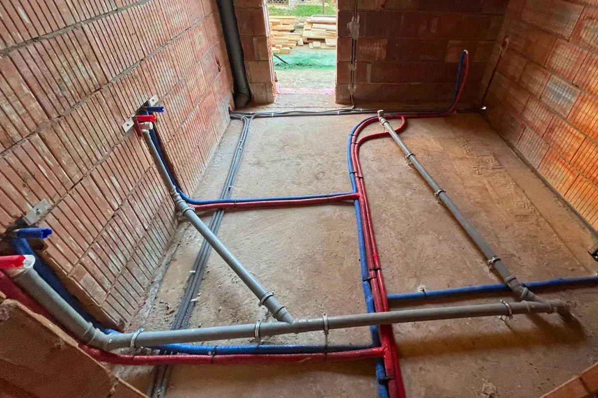 Ułożenie rur w wykopie, cennik bez materiału. Instalacja wodna i kanalizacyjna w trakcie budowy.