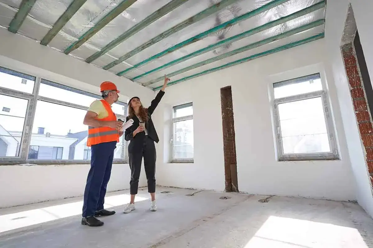 Inżynier i architektka omawiają projekt sufitu podwieszanego w nowym budynku.