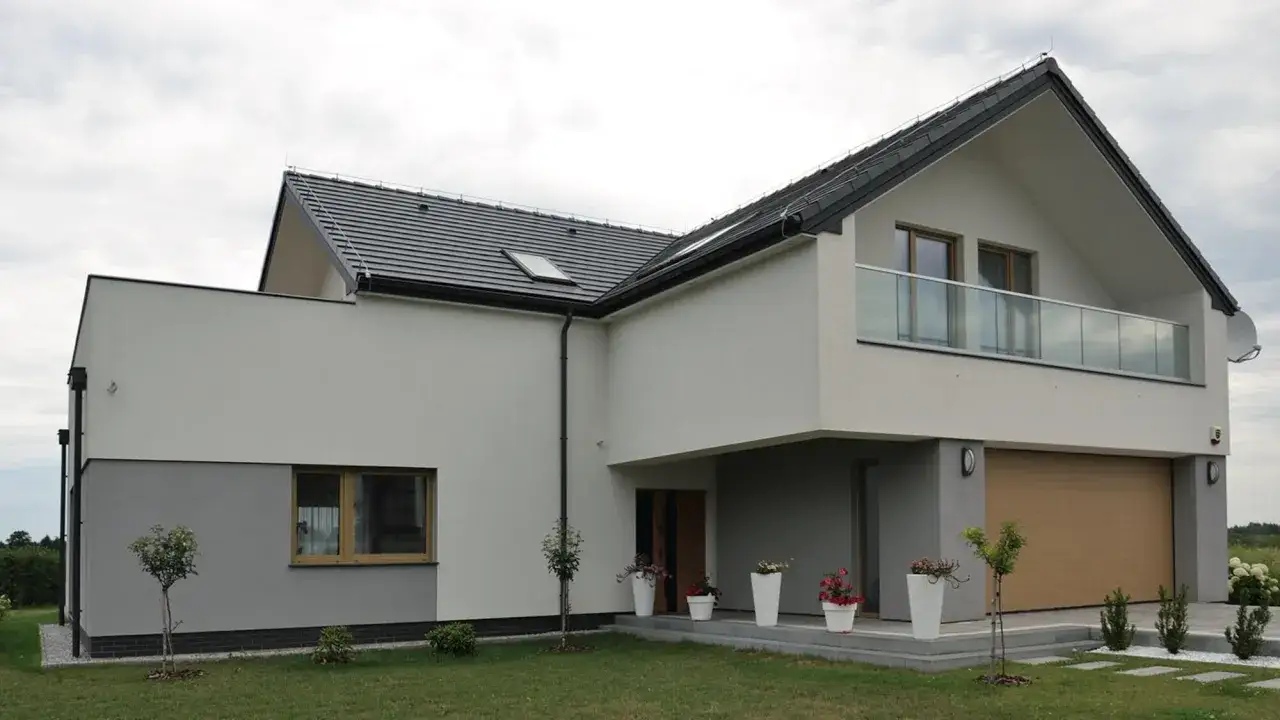 Nowoczesny dom z jasną elewacją, która podkreśla najmodniejsze kolory elewacji. Szarość i biel tworzą elegancką kompozycję.