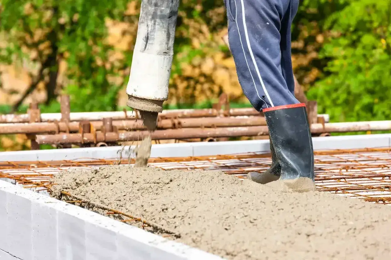 Beton c25/30 wylewany z pompy na zbrojenie. Budowa trwa, a solidna podstawa jest kluczowa.