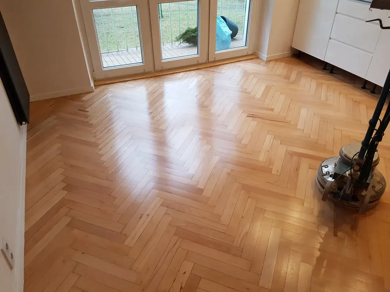 Odnowiony parkiet w jodełkę lśni po cyklinowaniu. Zastanawiasz się, ile kosztuje cyklinowanie parkietu? Ten efekt wart jest każdej złotówki!