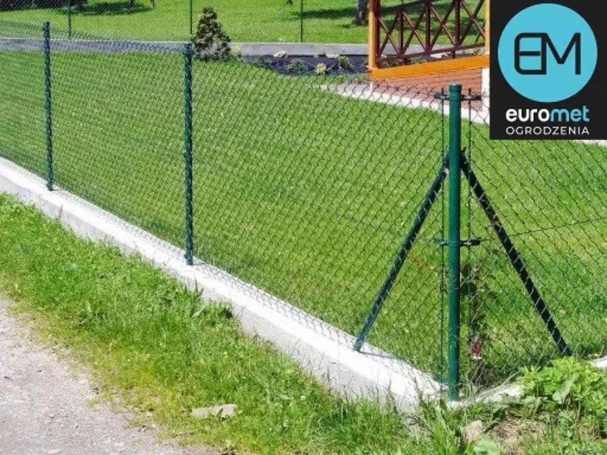 Zielona siatka ogrodzeniowa na betonowym podmurówce. Dowiedz się, ile kosztuje metr siatki ogrodzeniowej.